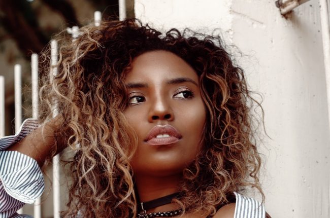 mulher jovem com cabelos cacheados com mechas