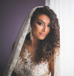 iStock 627013746 min 295x305 - jovem com cabelos cacheados com penteado para formatura