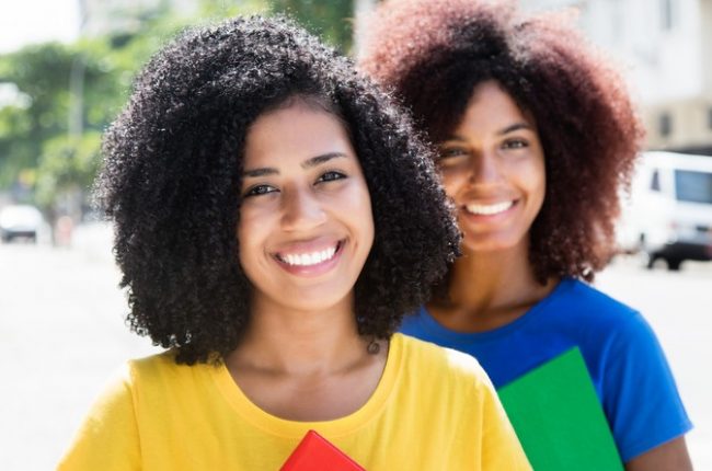 Two latin female students looking at camera