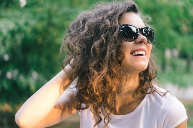 Portrait of a young smiling happy woman in sunglasses
