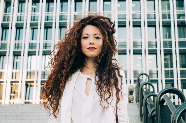 Young redhead business woman walking on the stairs